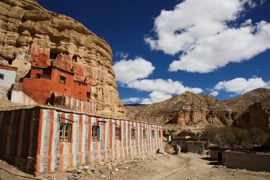 Impressive view of Choser village near Lo Manthang in Upper Mustang, a cultural highlight of the Lo Manthang Trek, with a Buddhist cave monastery built into the brown hills.