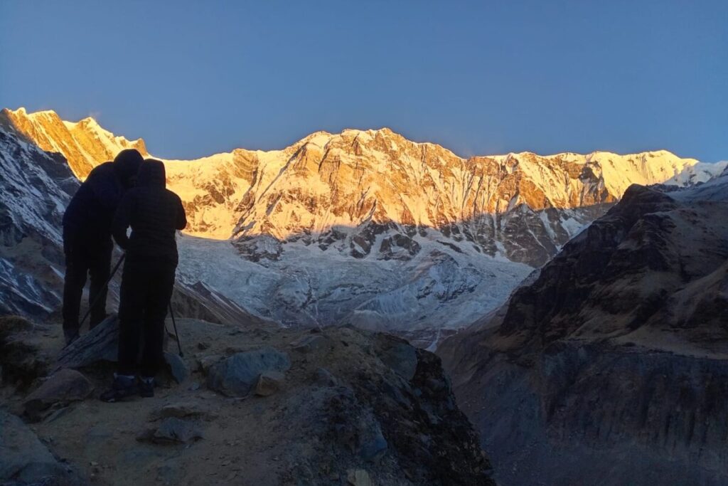 Trekkers watching sunrise over Annapurna mountains during the Annapurna Base Camp Trek in Nepal