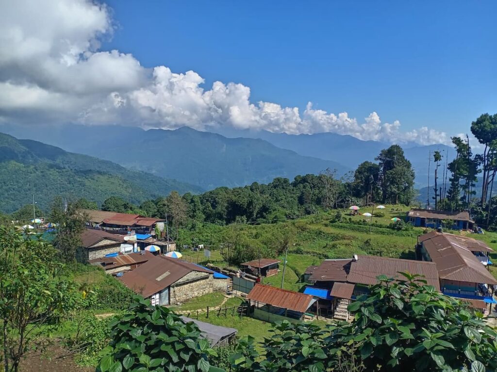 Aerial view of Dhampus village with traditional stone houses, green terraced hills and lush forest during the hike from Pokhara