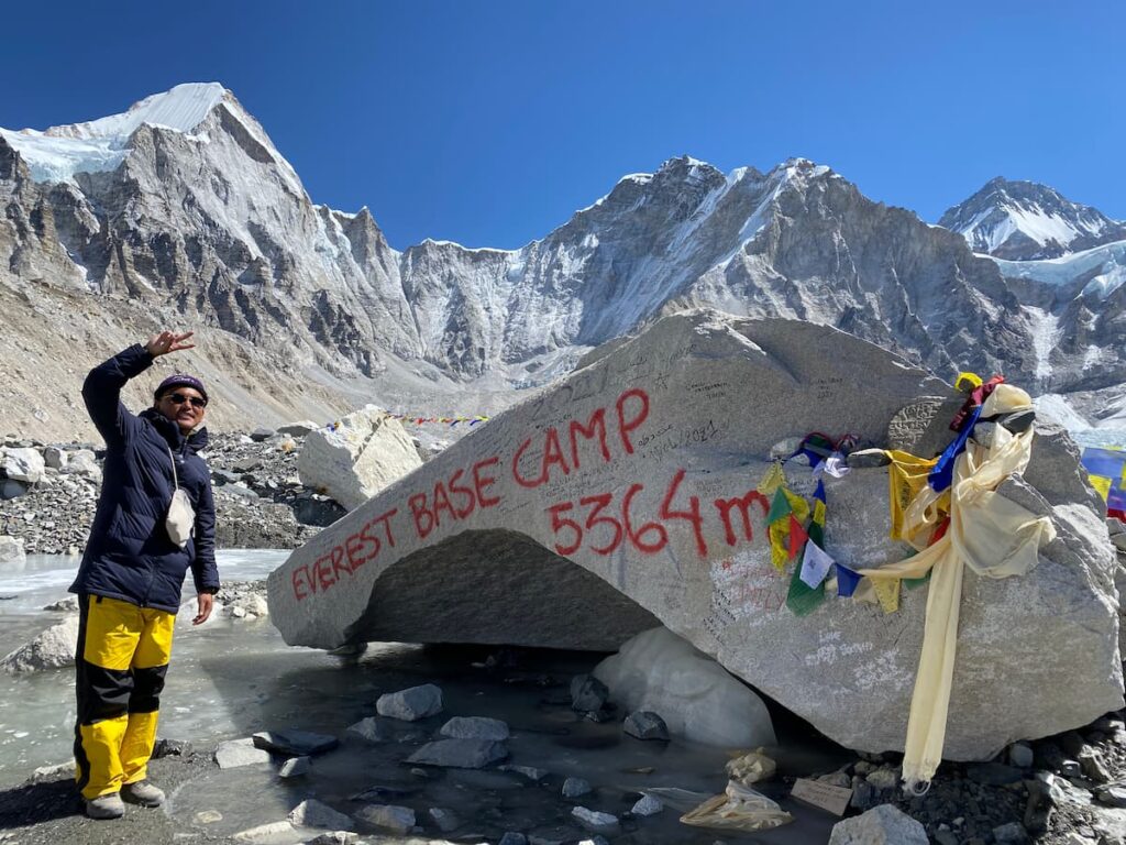 Trekker at Everest Base Camp 5364m sign rock on the Kala Patthar Trek route in the Khumbu region Nepal