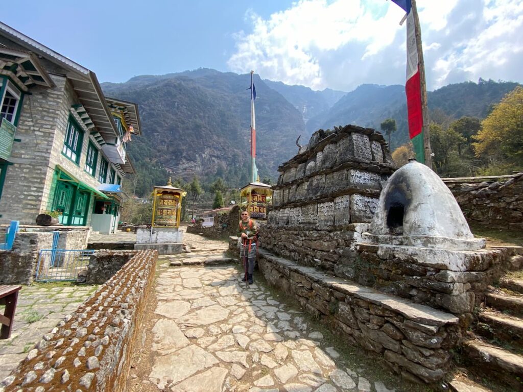 Trekker beside a traditional stupa in a Sherpa village on the Khumbu Trek Nepal route during the Everest Base Camp Trek