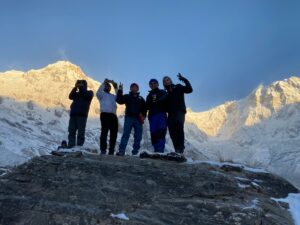 Group of trekkers celebrating at Annapurna Base Camp during a Nepal trekking tour at sunrise