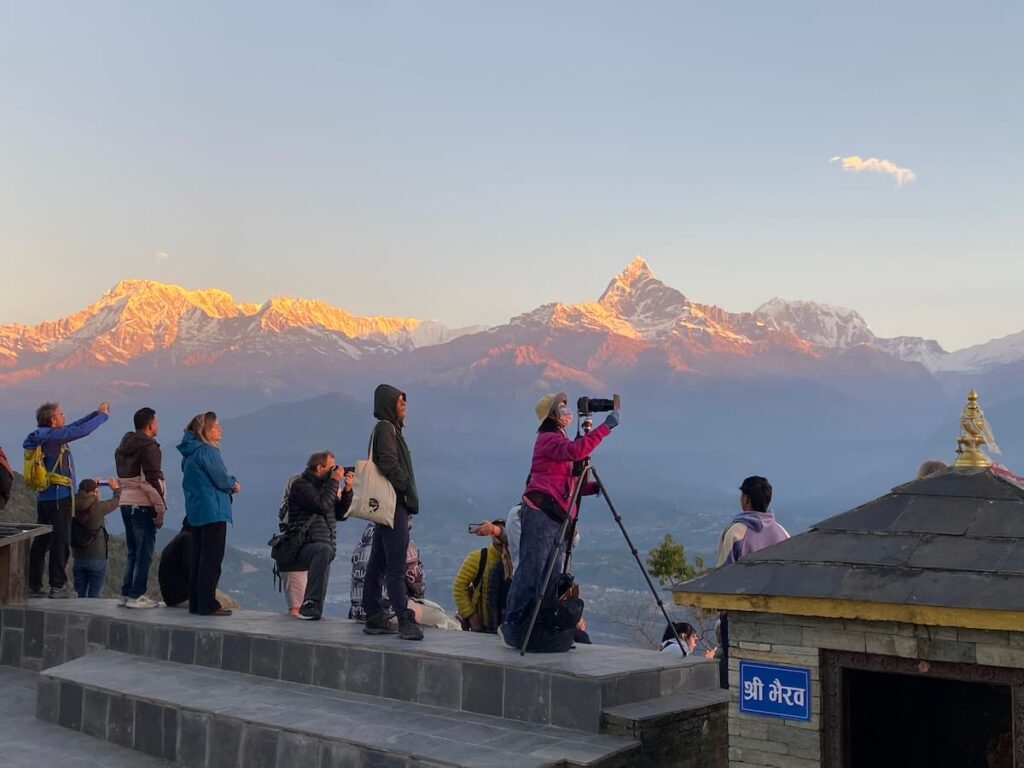 Hikers and photographers capturing alpenglow on the Annapurna range during a hiking near Pokhara experience at Sarangkot