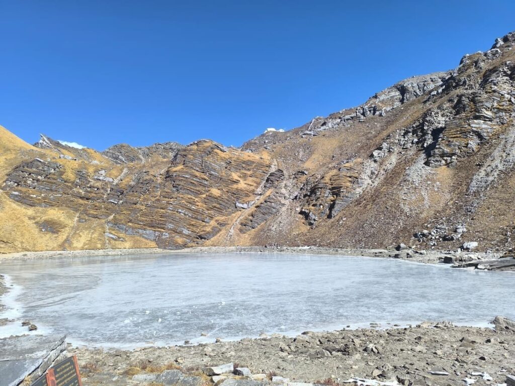 Frozen Khayer Lake at 4660m altitude surrounded by rocky Himalayan mountains on the Khopra trek in Nepal