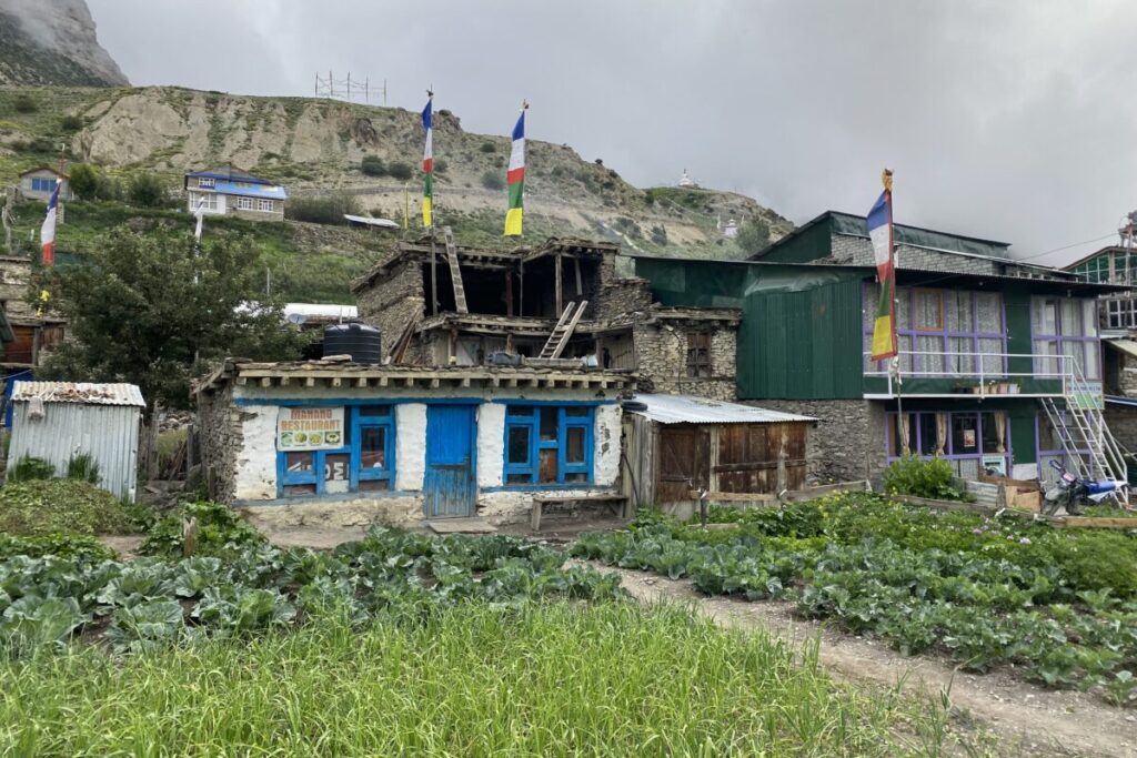 Traditional stone guesthouse with prayer flags in Manang village — a classic stop on the Annapurna Tea House Trek