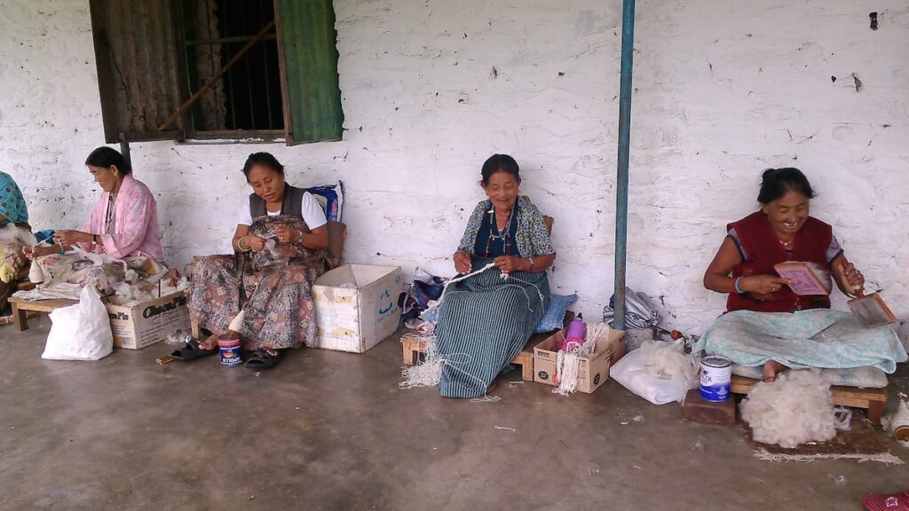 Tibetan women hand-spinning wool at a community cooperative supported by cultural tours in Pokhara