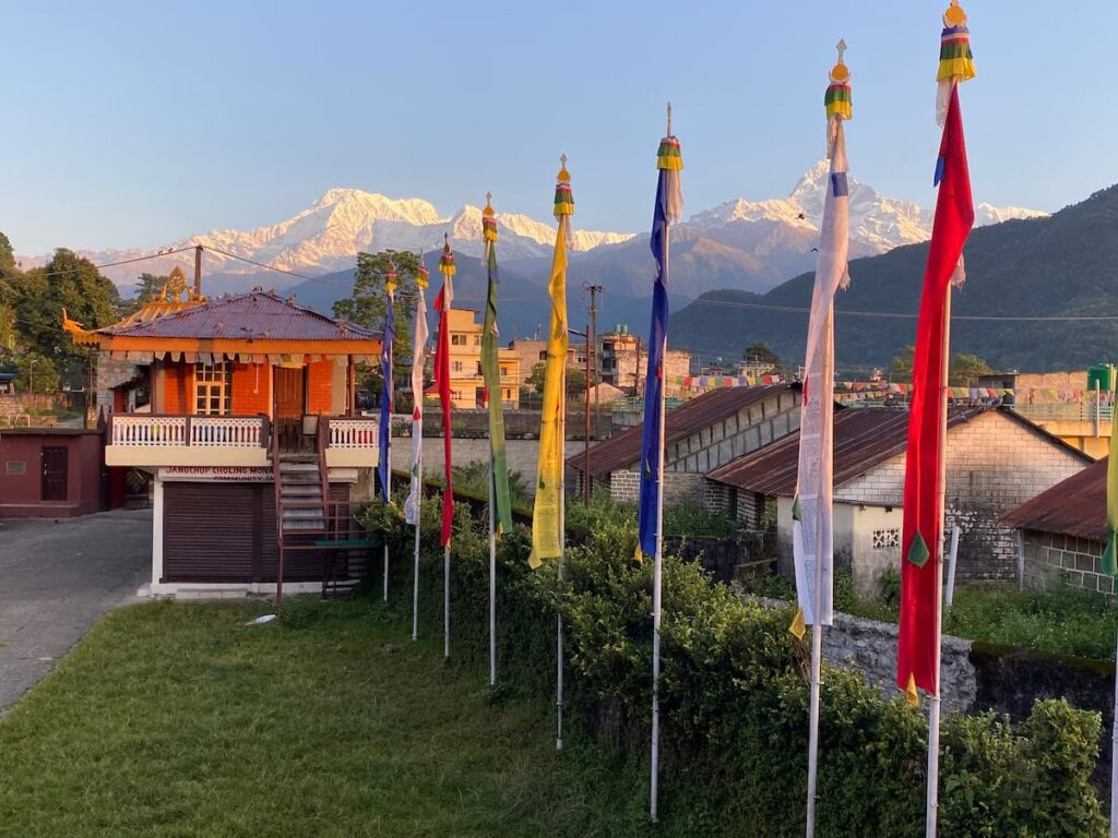 Jangchup Choling Monastery with colourful prayer flags and snow-capped Annapurna mountain range in the background