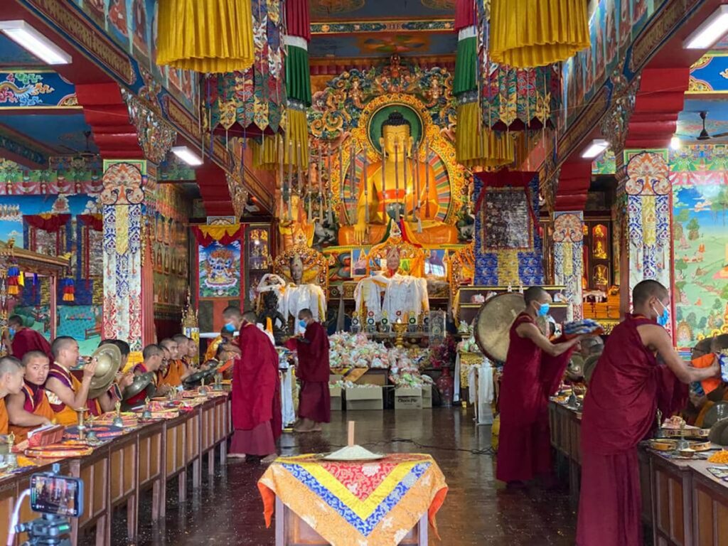 Buddhist monks performing morning prayer chanting inside a Tibetan monastery on the Buddhist cultural tour Pokhara