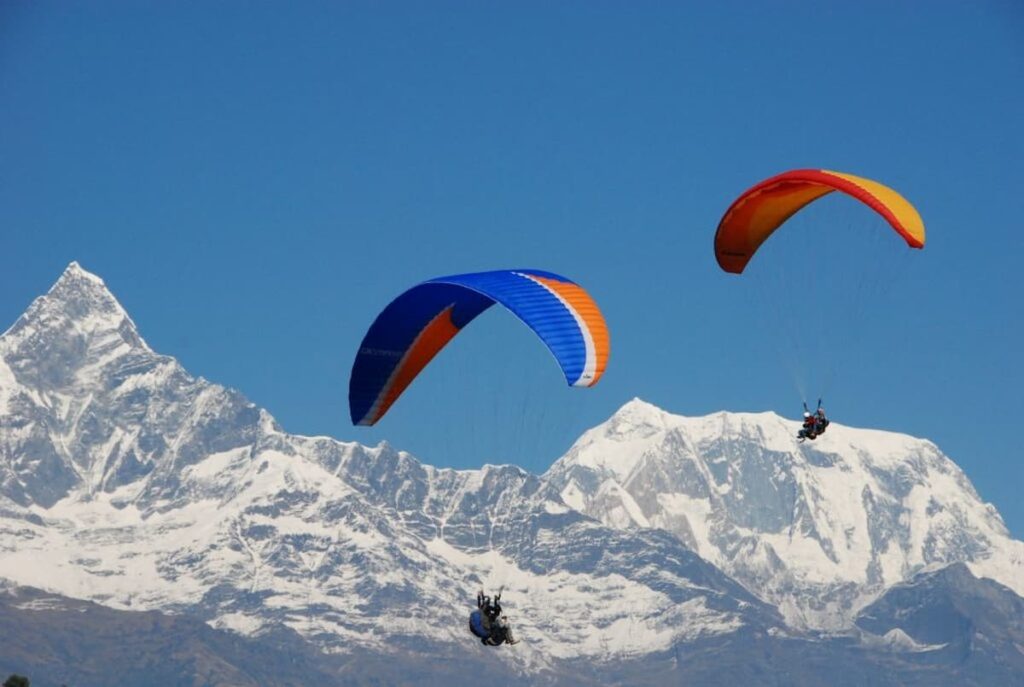 Tandem paragliding flight launching from Sarangkot viewpoint above Pokhara Nepal