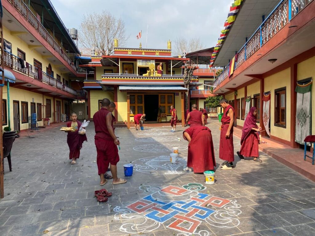 Young Buddhist monks painting sacred symbols at monastery — Pokhara monastery tour