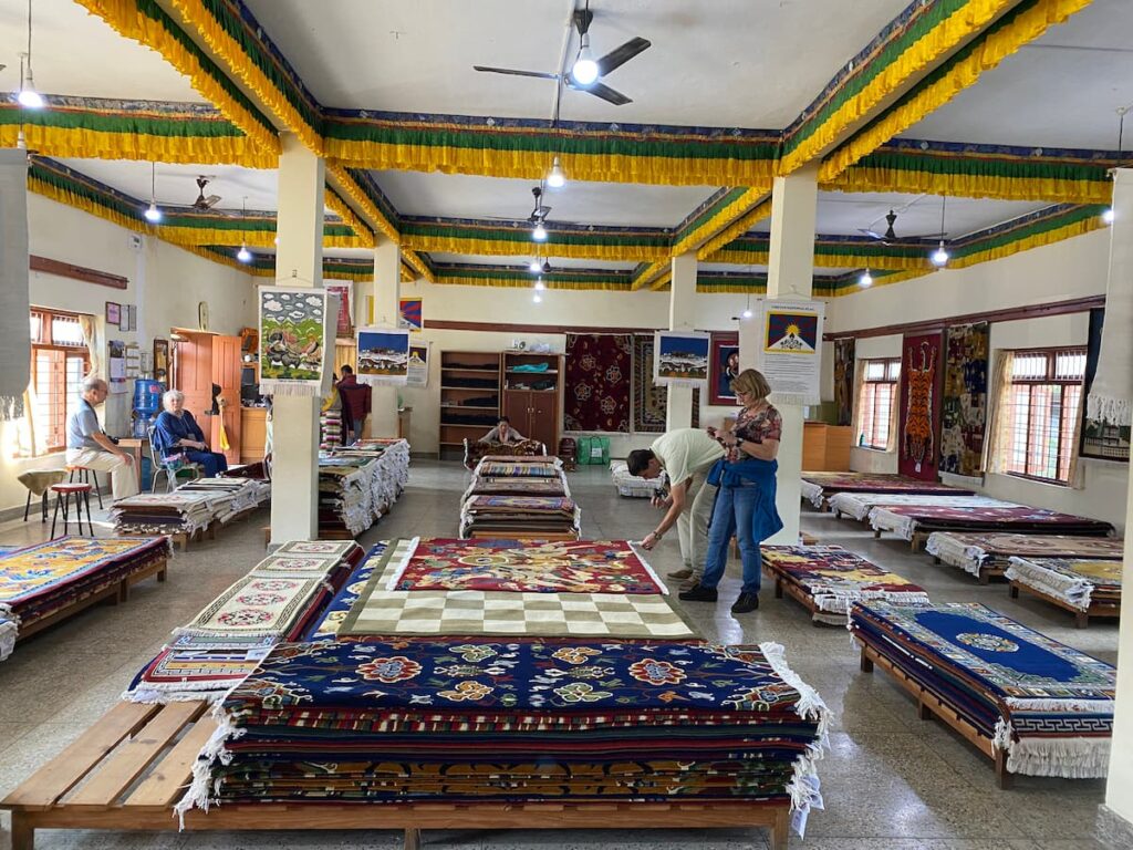 Colorful handmade Tibetan carpets displayed in showroom — Pokhara cultural day tour