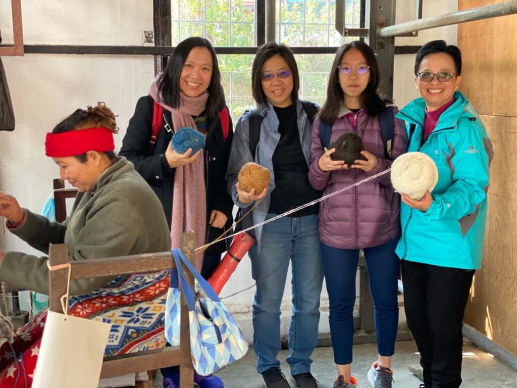 Tour guests at carpet weaving workshop during cultural experiences in Pokhara