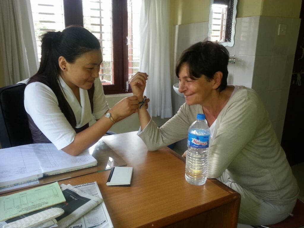Tibetan doctor performing a traditional pulse reading for a guest at the health clinic