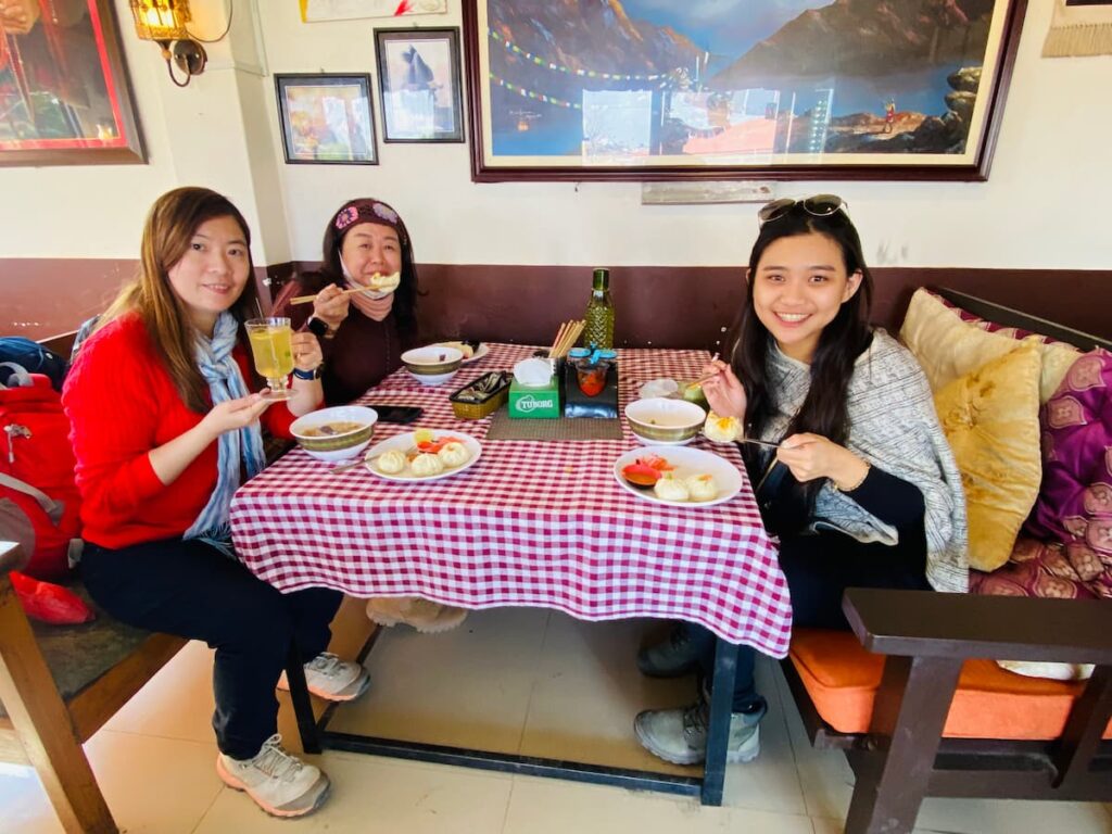 Full day cultural tour in Pokhara — guests enjoying traditional momos and thenthuk at a local family-run Tibetan restaurant