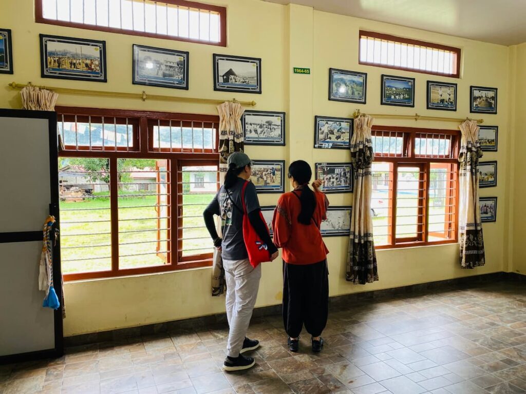 Guests exploring Tibetan history at the refugee settlement photo gallery on a cultural tour in Pokhara