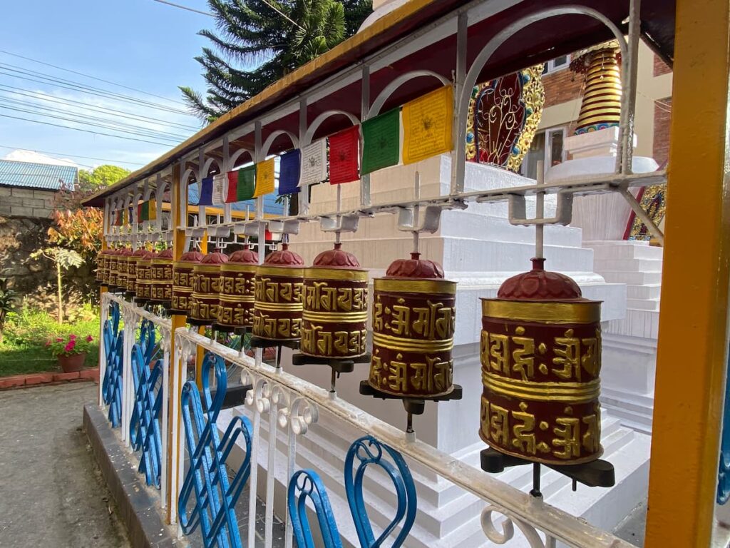 Row of golden and red Tibetan prayer wheels at a Buddhist monastery in Pokhara