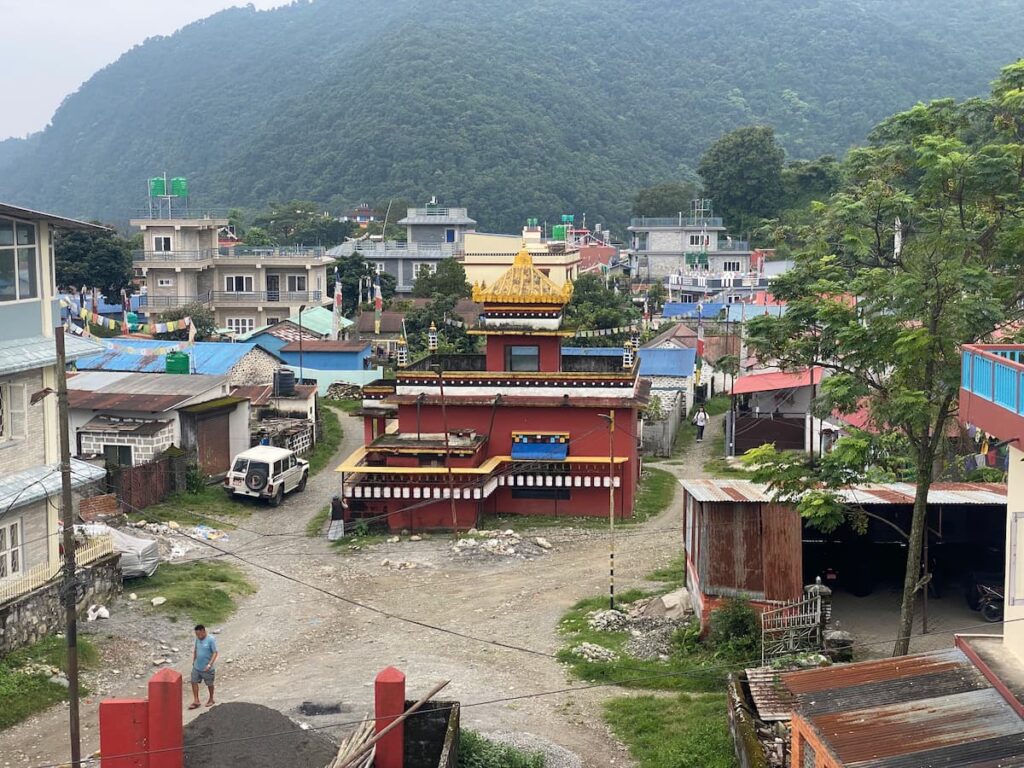 Aerial view of the Tibetan refugee settlement in Pokhara with a monastery building surrounded by traditional homes and green hills