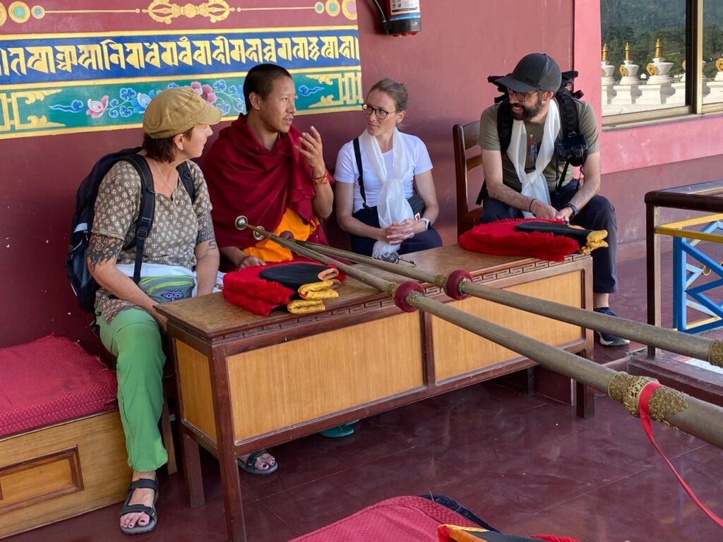 Tourists in conversation with a Tibetan monk at a monastery in Pokhara – half day cultural tour Pokhara