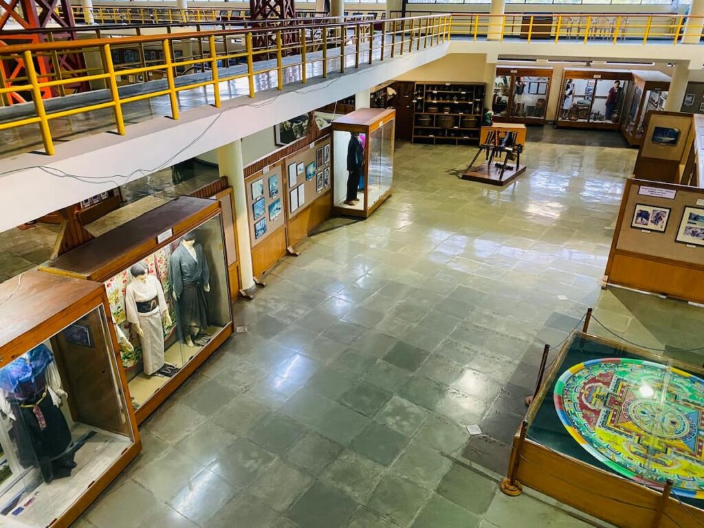 Interior of the International Mountain Museum in Pokhara showing climbing gear and exhibition displays — final stop on the Pokhara half-day sightseeing tour by car.