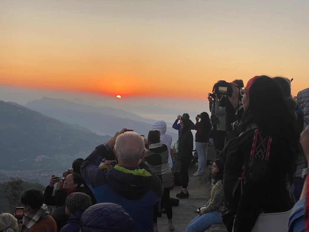 Travellers and tourists photographing the early morning sunrise from Sarangkot hill on a Pokhara morning tour