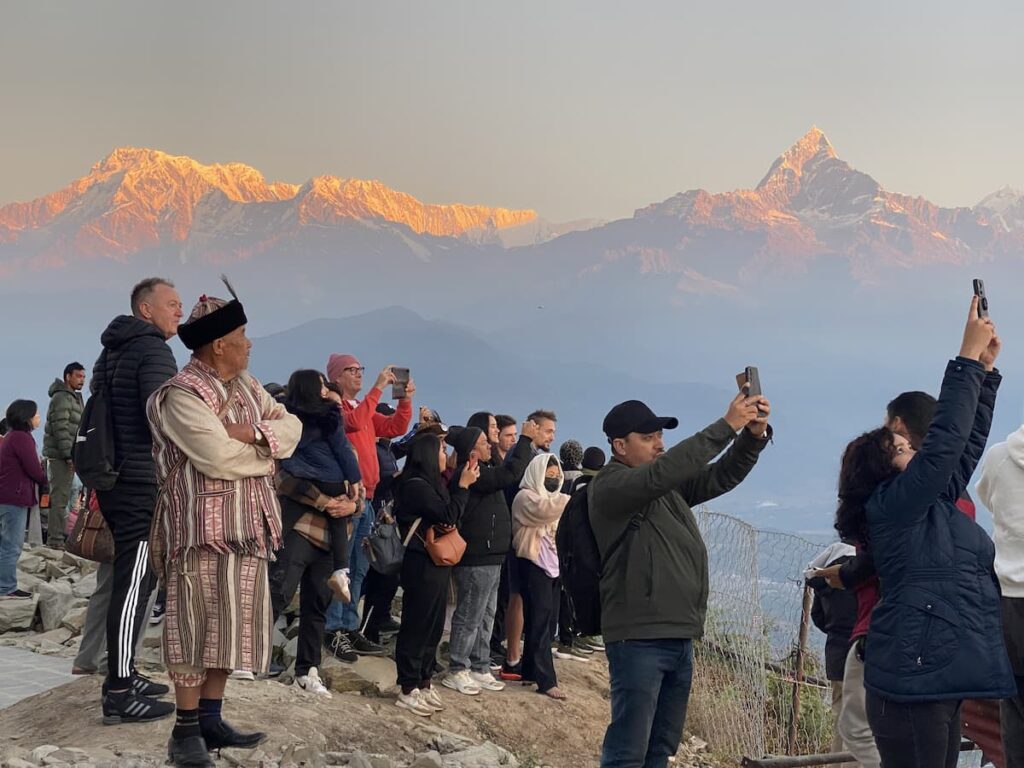 Visitors watching sunrise over Annapurna and Machhapuchhre peaks from Sarangkot viewpoint — one of the best places to visit in Pokhara