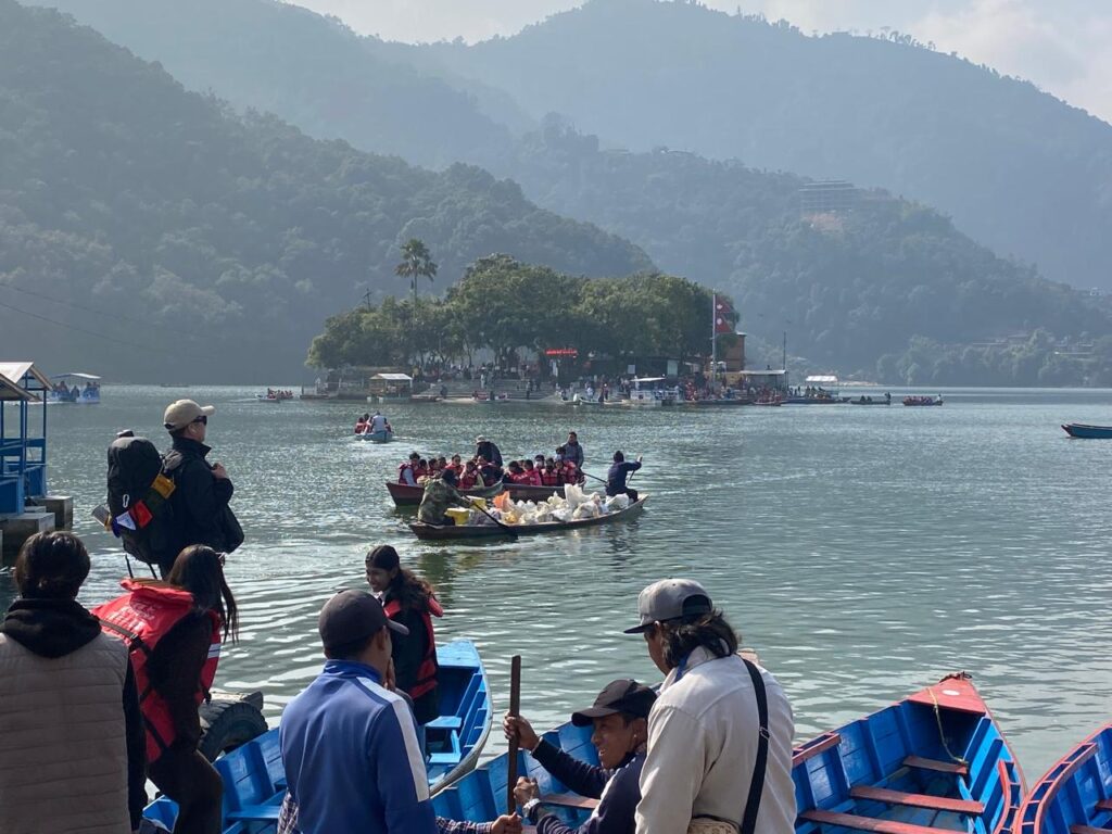 Traditional wooden boats carrying visitors across Fewa Lake towards Tal Barahi Island Temple in Pokhara.