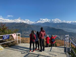 Guests admiring panoramic views of Annapurna range, Machhapuchhre, and Fewa Lake from the Japanese World Peace Pagoda viewpoint during a Pokhara half-day sightseeing hike.