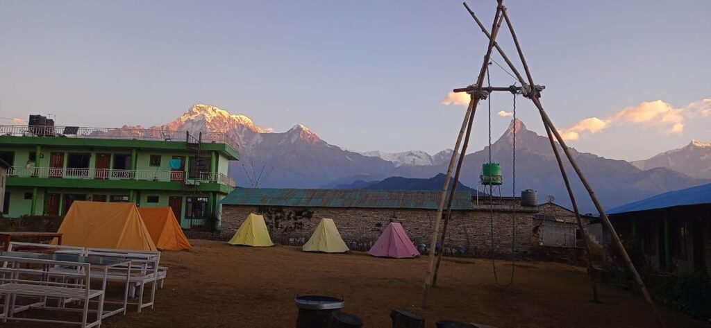 Colourful tents at the Australian Camp campsite with evening light on Machhapuchhre
