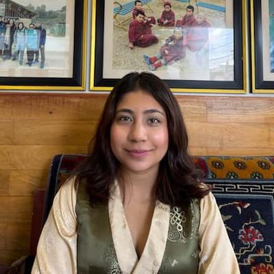 Alice, office staff at Tibetan Encounter, smiling indoors in traditional Tibetan attire