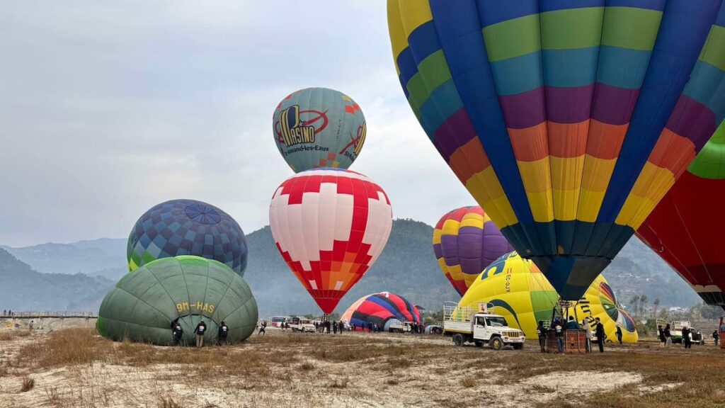 Pokhara hot air balloon crew inflating balloons of different colours side by side